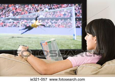 A woman reading a tv listings magazine View Large Photo Image Stock Photo - A woman reading a tv listings magazine. Fotosearch