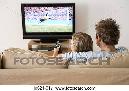 A young couple watching a football match on the tv View Large Photo Image Stock Photo - A young couple watching a football match on the tv. Fotosearch