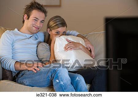 A young couple watching tv View Large Photo Image Stock Photo - A young couple watching tv. Fotosearch