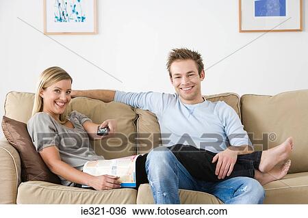 A young couple watching tv View Large Photo Image Stock Photograph - A young couple watching tv. Fotosearch