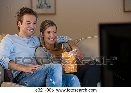 A young couple watching tv View Large Photo Image Stock Photography - A young couple watching tv. Fotosearch