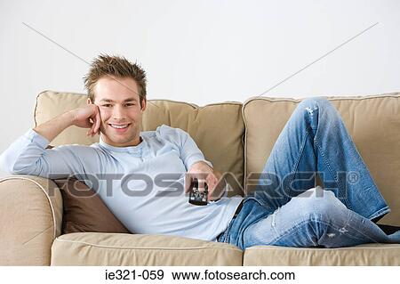 A young man watching tv View Large Photo Image Stock Photo - A young man watching tv. Fotosearch