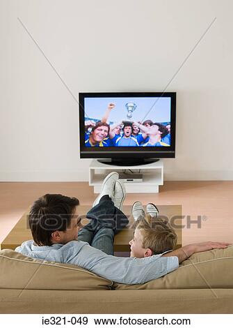 Stock Photo - Father and son watching a football match. Fotosearch