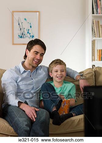 Father and son watching tv View Large Photo Image Stock Photography - Father and son watching tv. Fotosearch