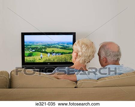 Stock Photography - Rear view of a senior couple watching tv. Fotosearch