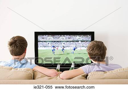 Two young men watching football on the tv View Large Photo Image Stock Photography - Two young men watching football on the tv. Fotosearch