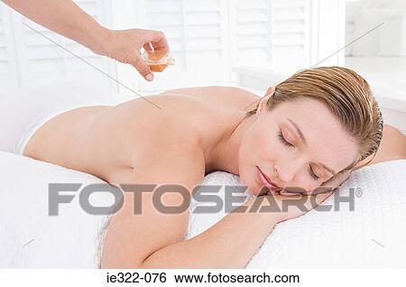 A masseuse applying oil to a womans back View Large Photo Image Stock Photograph - A masseuse applying oil to a womans back. Fotosearch