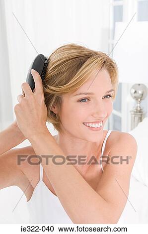A woman brushing her hair View Large Photo Image Stock Image - A woman brushing her hair. Fotosearch