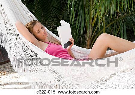 A woman in a hammock reading a book View Large Photo Image Stock Photography - A woman in a hammock reading a book. Fotosearch
