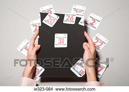 A person holding calendar dates View Large Photo Image Picture - A person holding calendar dates. Fotosearch