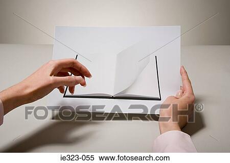 Stock Photography - A woman holding a photograph of a book. Fotosearch