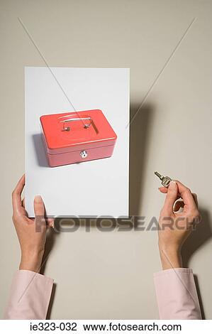 A woman holding a photograph of a cash box and a key View Large Photo Image Stock Image - A woman holding a photograph of a cash box and a key. Fotosearch
