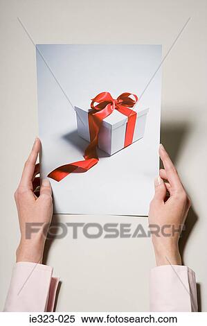 A woman holding a photograph of a gift View Large Photo Image Stock Photography - A woman holding a photograph of a gift. Fotosearch