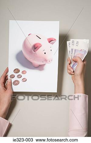 A woman holding a photograph of a piggy bank and money View Large Photo Image Stock Image - A woman holding a photograph of a piggy bank and money. Fotosearch