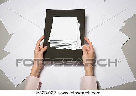 A woman holding a photograph of a stack of paper View Large Photo Image Stock Image - A woman holding a photograph of a stack of paper. Fotosearch