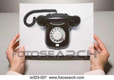 A woman holding a photograph of a telephone View Large Photo Image Stock Photo - A woman holding a photograph of a telephone. Fotosearch