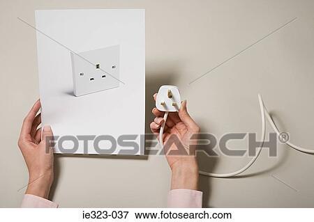 A woman holding a photograph of a socket and a plug View Large Photo Image Stock Photo - A woman holding a photograph of a socket and a plug. Fotosearch