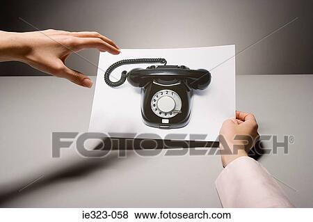 A woman holding a photograph of a telephone View Large Photo Image Stock Photo - A woman holding a photograph of a telephone. Fotosearch