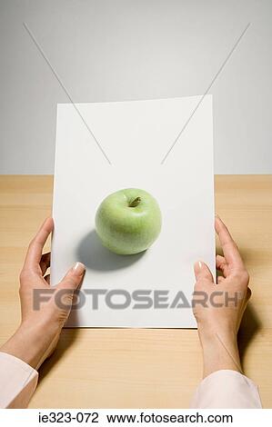 A woman holding a photograph of an apple View Large Photo Image Stock Image - A woman holding a photograph of an apple. Fotosearch