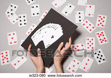 Stock Image - A woman holding a photograph of cards. Fotosearch