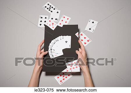 Stock Photography - A woman holding a photograph of cards. Fotosearch