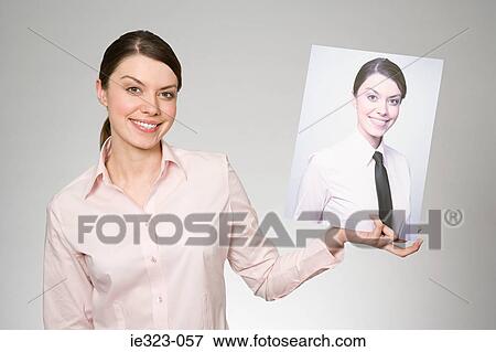 A woman holding a photograph of herself View Large Photo Image Stock Photo - A woman holding a photograph of herself. Fotosearch