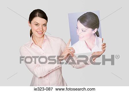 A woman holding a photograph of herself View Large Photo Image Stock Photo - A woman holding a photograph of herself. Fotosearch