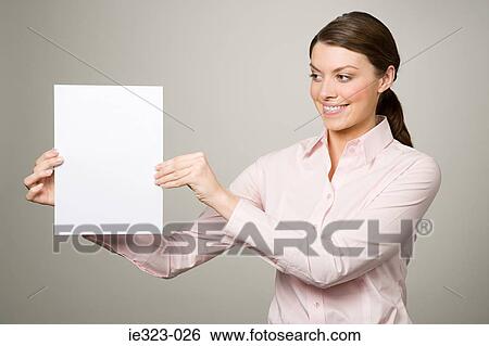 A woman holding a piece of paper View Large Photo Image Stock Photograph - A woman holding a piece of paper. Fotosearch