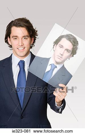 Portrait of a man holding a photograph of himself View Large Photo Image Stock Image - Portrait of a man holding a photograph of himself. Fotosearch