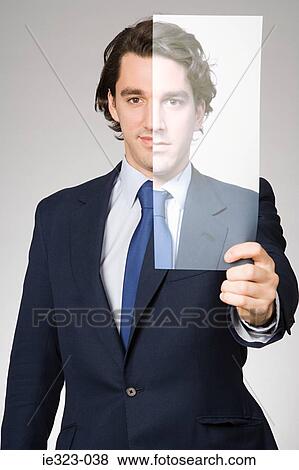 Portrait of a man holding a photograph of himself View Large Photo Image Stock Photo - Portrait of a man holding a photograph of himself. Fotosearch