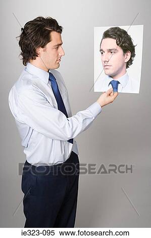Portrait of a man holding a photograph of himself View Large Photo Image Stock Photography - Portrait of a man holding a photograph of himself. Fotosearch