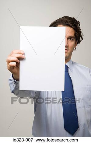 Stock Photo - Portrait of a man holding a piece of paper. Fotosearch