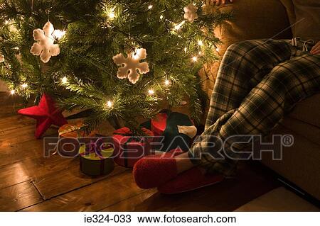 A man sat next to a christmas tree View Large Photo Image Stock Image - A man sat next to a christmas tree. Fotosearch