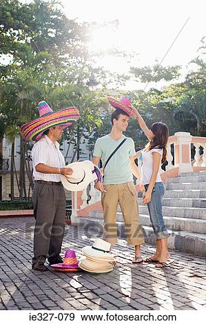 Couple and man selling hats View Large Photo Image Stock Photo - Couple and man selling hats. Fotosearch