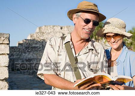 Couple by ruins with guidebook View Large Photo Image Stock Image - Couple by ruins with guidebook. Fotosearch