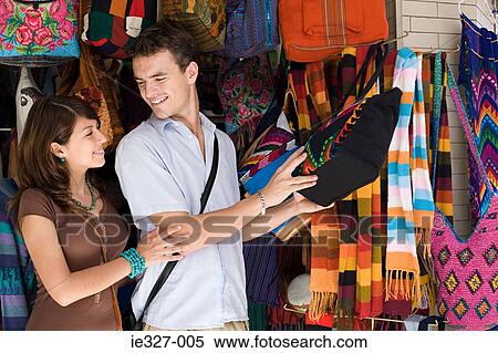 Stock Photography - Couple looking at bag on stall. Fotosearch