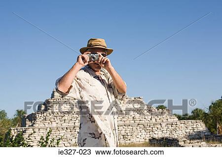 Man by ruins with camera View Large Photo Image Stock Image - Man by ruins with camera. Fotosearch