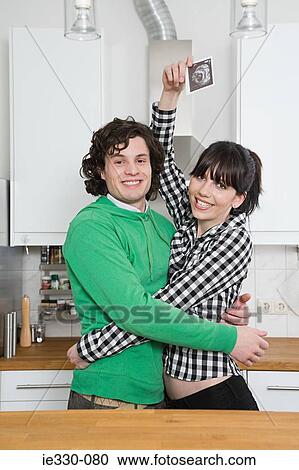 Hugging couple with a baby scan picture View Large Photo Image Stock Image - Hugging couple with a baby scan picture. Fotosearch
