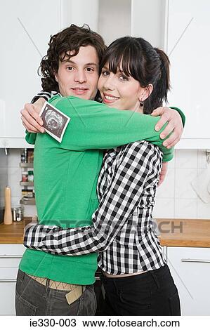 Pregnant woman hugging partner View Large Photo Image Stock Image - Pregnant woman hugging partner. Fotosearch