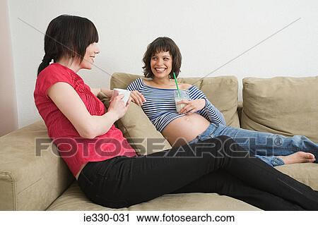 Pregnant woman relaxing with friend View Large Photo Image Stock Image - Pregnant woman relaxing with friend. Fotosearch