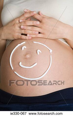 Smiley face on a pregnant stomach View Large Photo Image Stock Photo - Smiley face on a pregnant stomach. Fotosearch