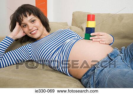 Stock Photo - Woman balancing toy blocks on stomach. Fotosearch