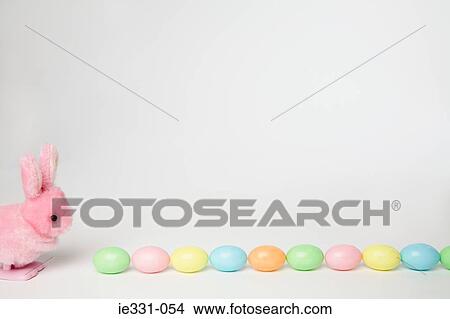 Picture - A toy rabbit and easter eggs in a row. Fotosearch