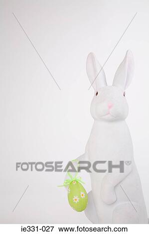 Easter bunny holding an easter egg View Large Photo Image Stock Photo - Easter bunny holding an easter egg. Fotosearch