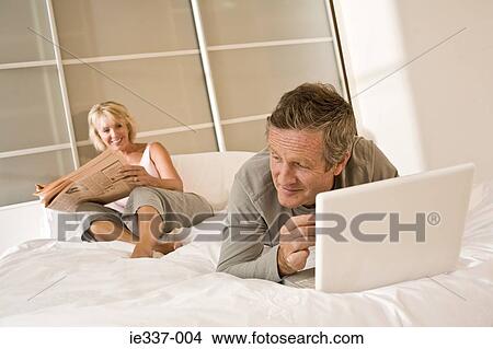 Picture - Couple relaxing on bed. Fotosearch