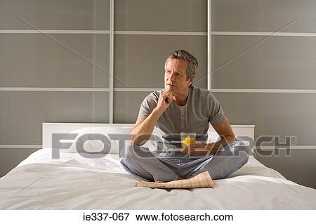 Man on bed thinking View Large Photo Image Stock Photo - Man on bed thinking. Fotosearch