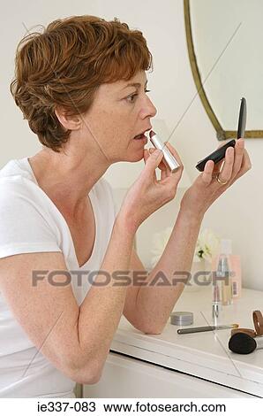 Woman applying lipstick View Large Photo Image Stock Image - Woman applying lipstick. Fotosearch