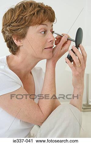 Woman applying make up View Large Photo Image Stock Image - Woman applying make up. Fotosearch