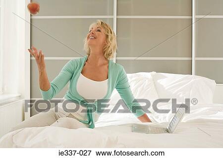 Woman with apple and laptop View Large Photo Image Stock Photo - Woman with apple and laptop. Fotosearch