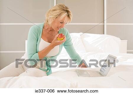 Woman with apple and laptop View Large Photo Image Stock Photograph - Woman with apple and laptop. Fotosearch